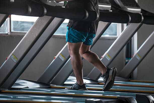 istock Man Jogging on Treadmill in Gym daytime indoors 2248249003