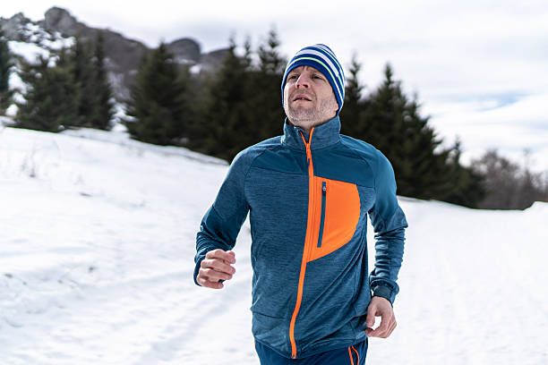 istock Man trail running in snowy winter mountains 2248249599