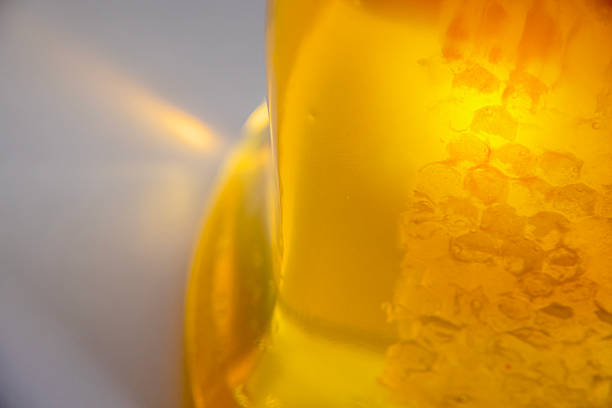 Golden honey liquid in a clear container with dispersion
