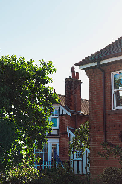White building with a tiled roof and chimneys. Traditional white house with vibrant red roof
