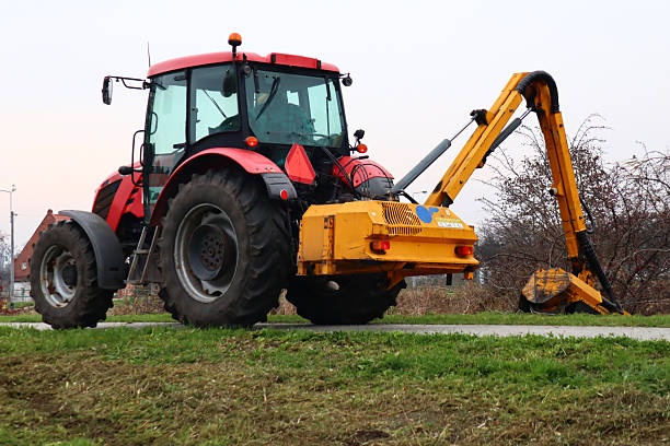 istock Red Tractor with Boom Mower on a Grassy Bank 2248250688