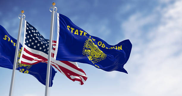 istock Oregon state flags waving in the wind with the american flags on a clear day 2248253056