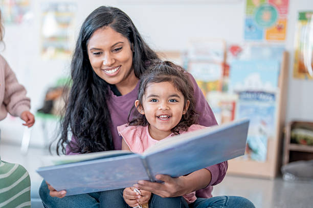 istock Mother And Daughter Reading Together, Smiling In Bright Library Setting 2248253194