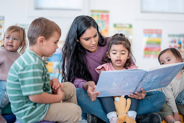 istock Mother Reading Book With Diverse Group Of Children In Classroom Setting, Engaged Learning Moment 2248253232