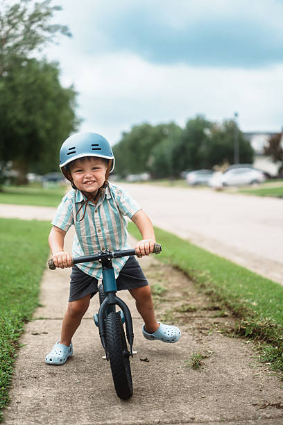istock Smiling Young Boy Riding Balance Bike 2248253825