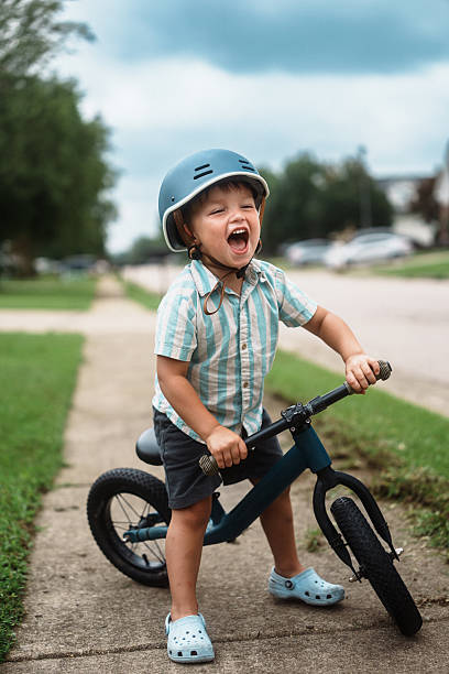 istock Joyful Little Boy Laughing While Riding Balance Bike 2248253827