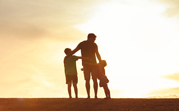 istock Father and Children Silhouette at Sunset 2248253944