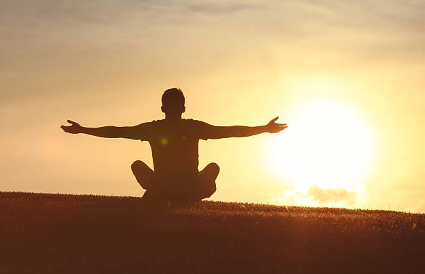 istock Silhouette of Man Meditating with Open Arms at Sunset 2248253974
