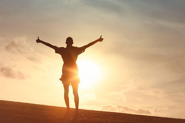 istock Female Silhouette Arms Open in Sunset Light 2248253985