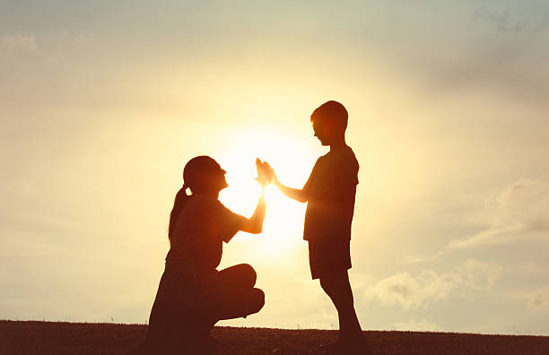 istock Silhouette of Parent and Child Sharing a High Five 2248253987