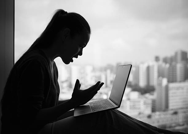 istock Frustrated woman yelling at laptop, expressing stress and anger while working online 2248254616