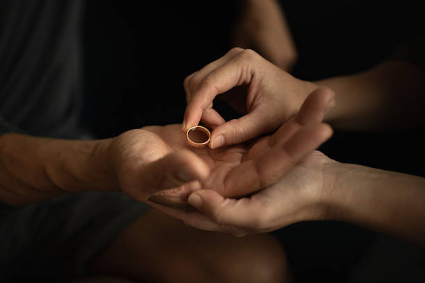 istock Close-up of hands exchanging a ring during emotional relationship decision 2248254672