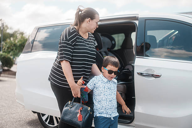 istock Mom Helping Son Out of Minivan 2248254685