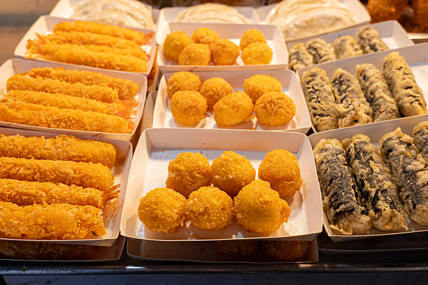 Korean street food featuring deep-fried tempura style snacks, crispy gim mari, and shrimp at a bustling market stall