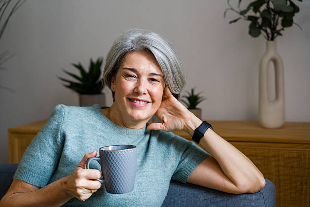 istock Senior woman smiling enjoying warm beverage at home 2248259131