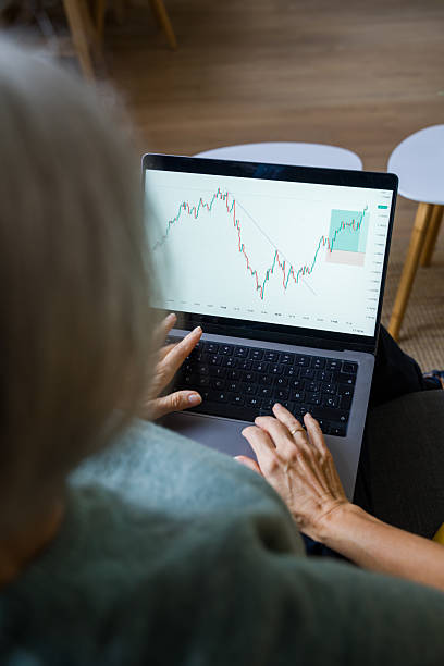 istock Senior woman analyzing stock market chart on laptop 2248259355