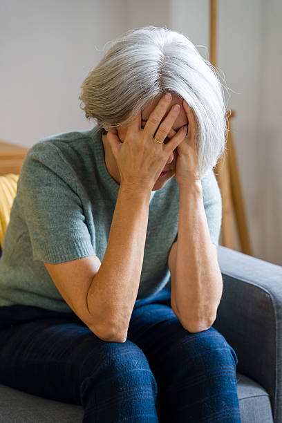 istock Senior woman feeling stressed and suffering headache at home 2248259883