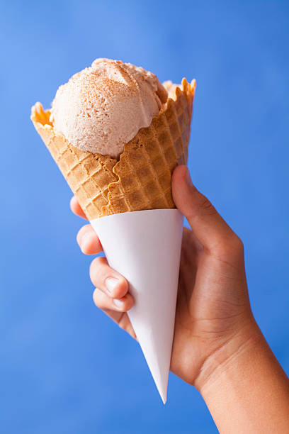 istock Holding an ice cream cone on a blue background 2248261354