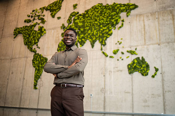 istock Smiling businessman standing against sustainable moss world map 2248261515