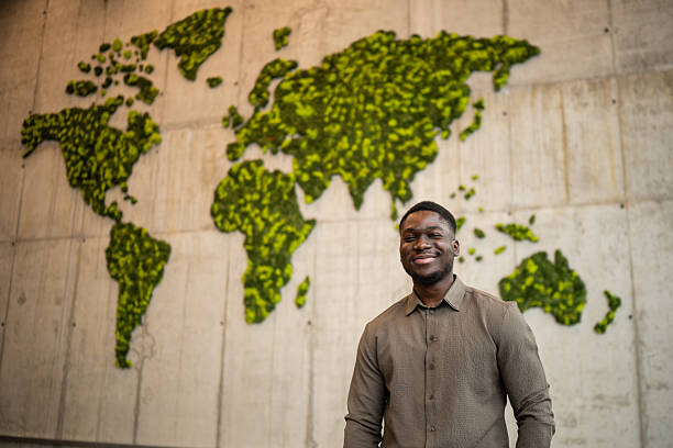 istock Young man smiling by green moss world map 2248261517