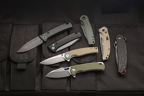 istock A collection of six modern folding knives displayed on a black tactical gear surface. 2248261940