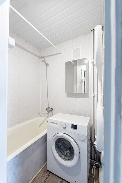 istock Compact Bathroom With Bathtub and Washing Machine in a Bright Clean Interior 2248264822