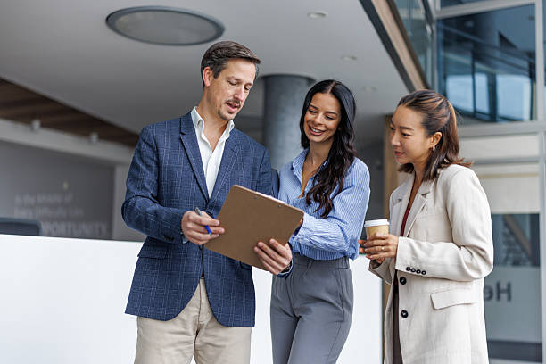 istock Business colleagues collaborating on documents in office hallway 2248265139