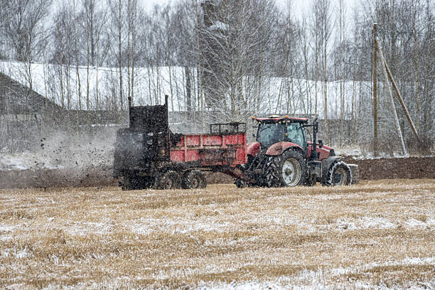 istock Winter Tractor Spreading Manure on Snow-Covered Field during Light Snowfall 2248266402