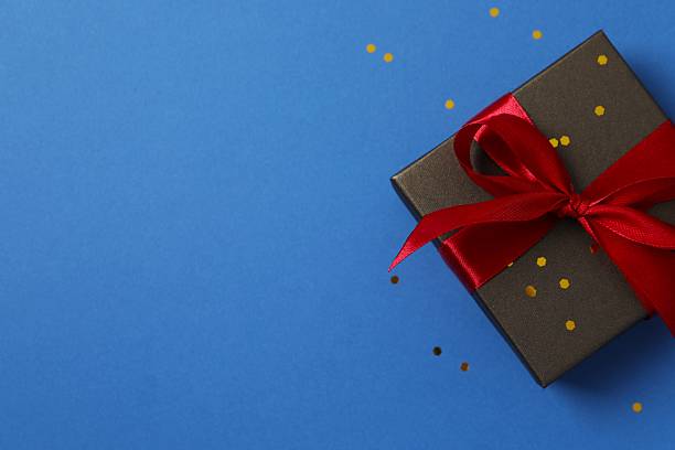 istock Small Luxury gift box with red bow on light blue. Side view monochrome . Corporate gift concept or birthday party. Festive sale copy space 2248266815