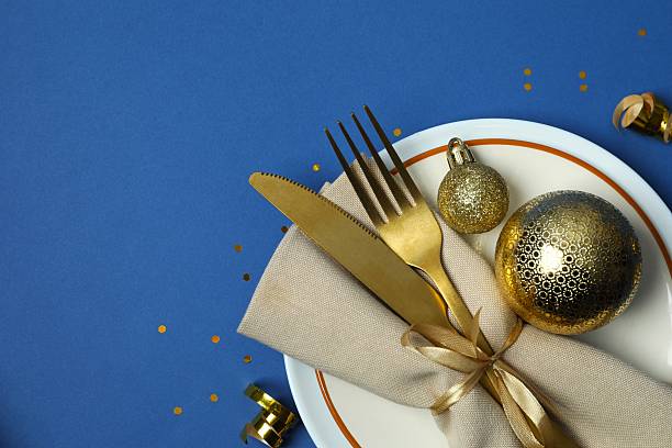istock Festive Christmas table setting with plate, cutlery and decorations on blue background 2248266851