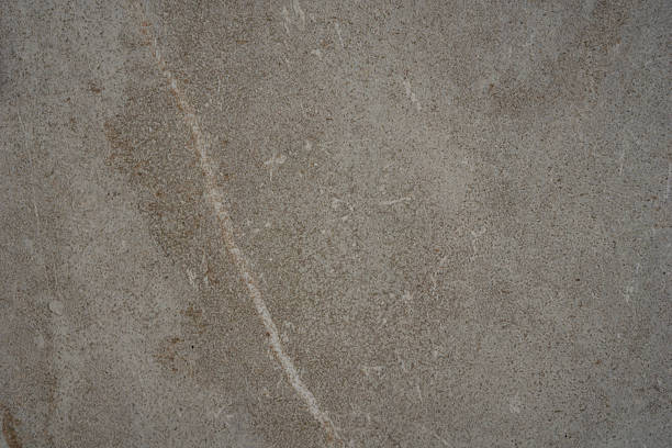 dull gray textured stone surface background with diagonal white and brown veins and scratch marks concept of architecture, construction, tile manufacturing