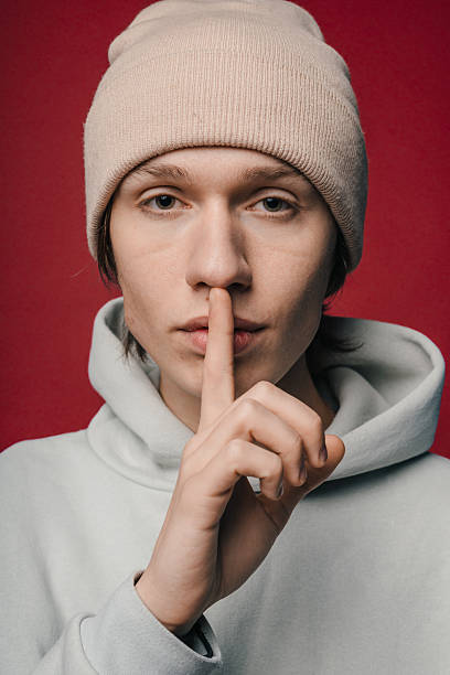 istock fashionconscious youth communicates confidentiality through gesture and expression in studio environment 2248271571