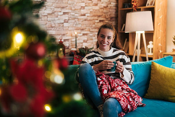 istock Woman smiling while relaxing on sofa during christmas 2248278398