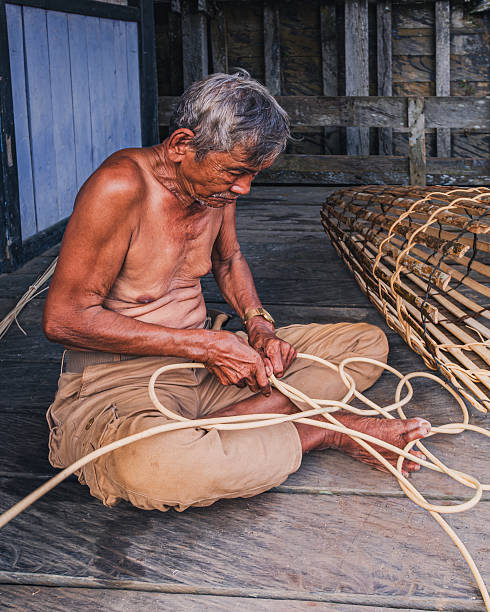 A resident is knitting Rattan handicrafts in the Keude Bieng area, Lhooknga, Aceh Besar, Aceh Province (04-17-2020). Rattan is one of the products of the earth and has become the people's livelihood with rattan handicrafts. But as a result of being plagued by Pandemic Coid-19 and triggered by increasingly reduced forest areas due to the opening of plantation areas and forest fires, making the existence of these forest ropes increasingly reduced so that the craftsmen overwhelmed getting raw rattan. In addition they are also difficult to market their production because Corona Virus is still threatening.