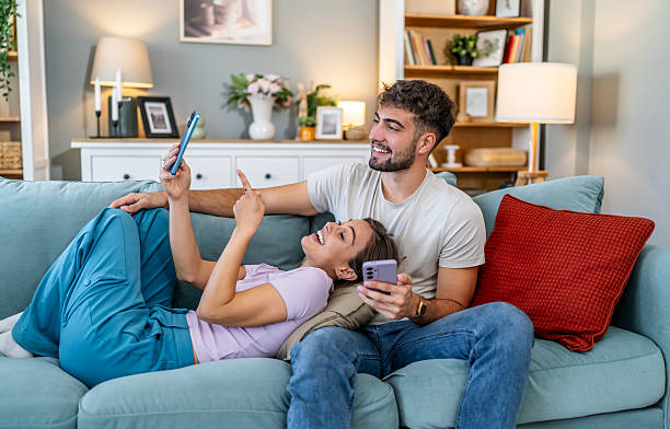 istock Couple relaxing on couch sharing phone content 2248279845