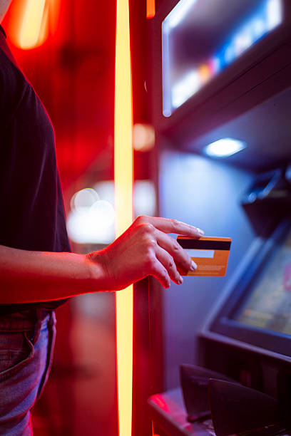 istock Person Using Credit Card At ATM With Neon Red And Blue Lighting 2248279871