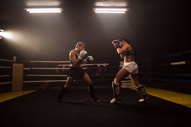 istock Women boxers spar in gym ring during match 2248280886