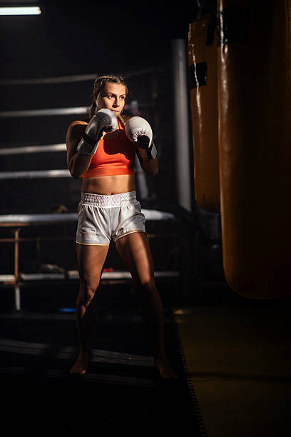 istock Female boxer training in gym with punching bag 2248280930
