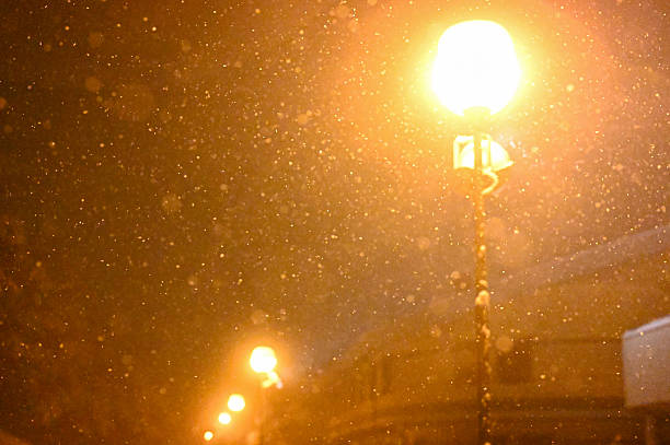 istock Night snow falling under glowing street lights 2248285296