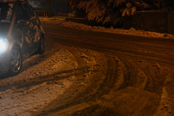 istock Car driving on snowy road at night 2248285617