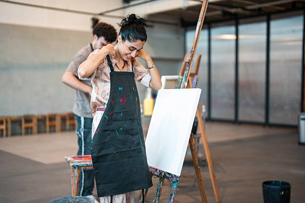 Young Asian Woman Painting Outdoors with Headphones, Focused Teen Girl Artist at Easel in Green Garden