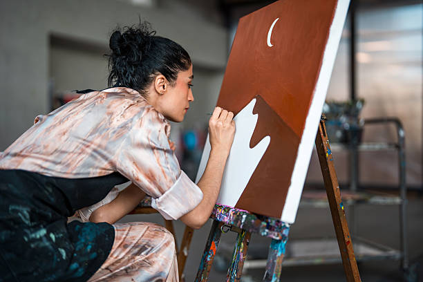 istock Middle Eastern Female Artist Painting Abstract Landscape in a Bright Creative Studio 2248286768