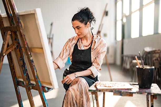 istock Middle Eastern Female Artist Painting in Bright Studio With Natural Light and Creative Atmosphere 2248286785