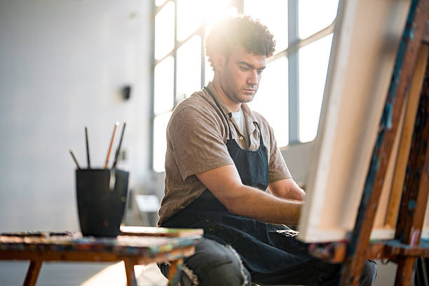 istock Young Middle Eastern Male Artist Painting in Bright Modern Studio 2248286787
