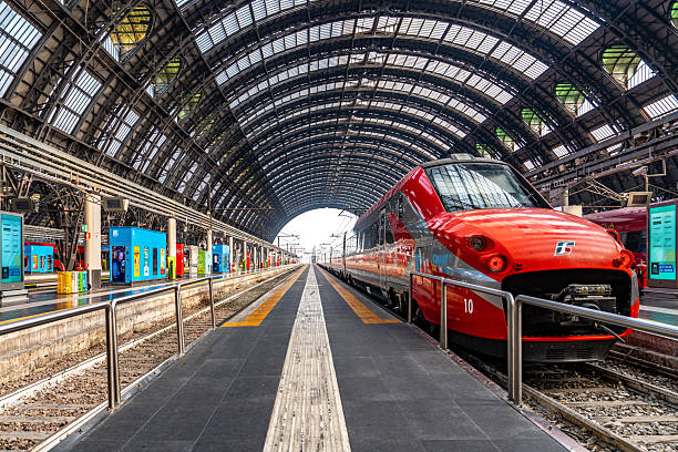 Fast moving red modern train with blurred motion on a railway station.