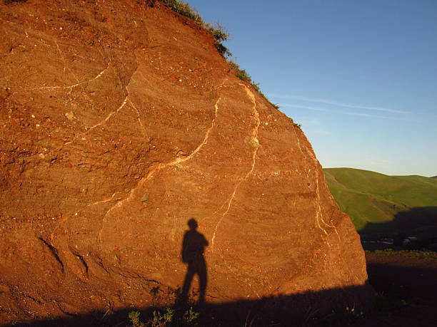 Shadow of Hiker on Rock Face at Sunset