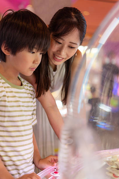 istock Family playing crane game in amusement arcade 2248289651