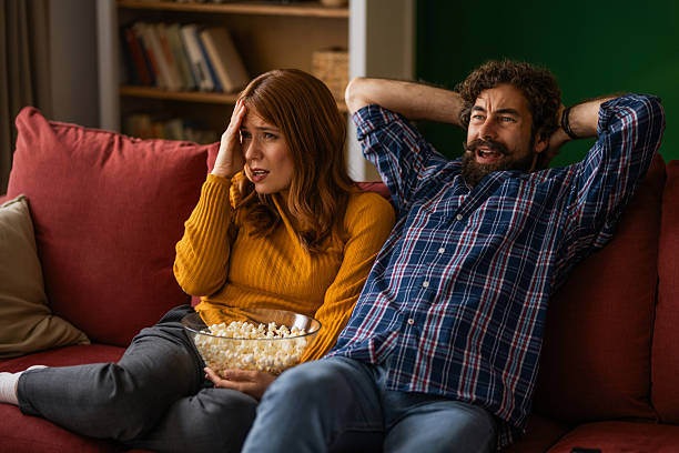 istock Displeased couple watching tv at home. 2248294631
