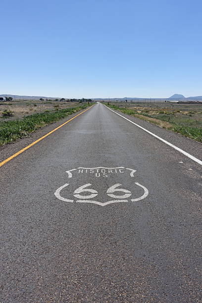 Ground level road view of Route 66 with logo in the Mojave Desert.