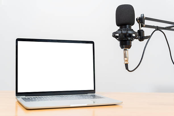 istock Laptop with blank white screen and professional studio microphone setup for podcast recording workspace 2248299651